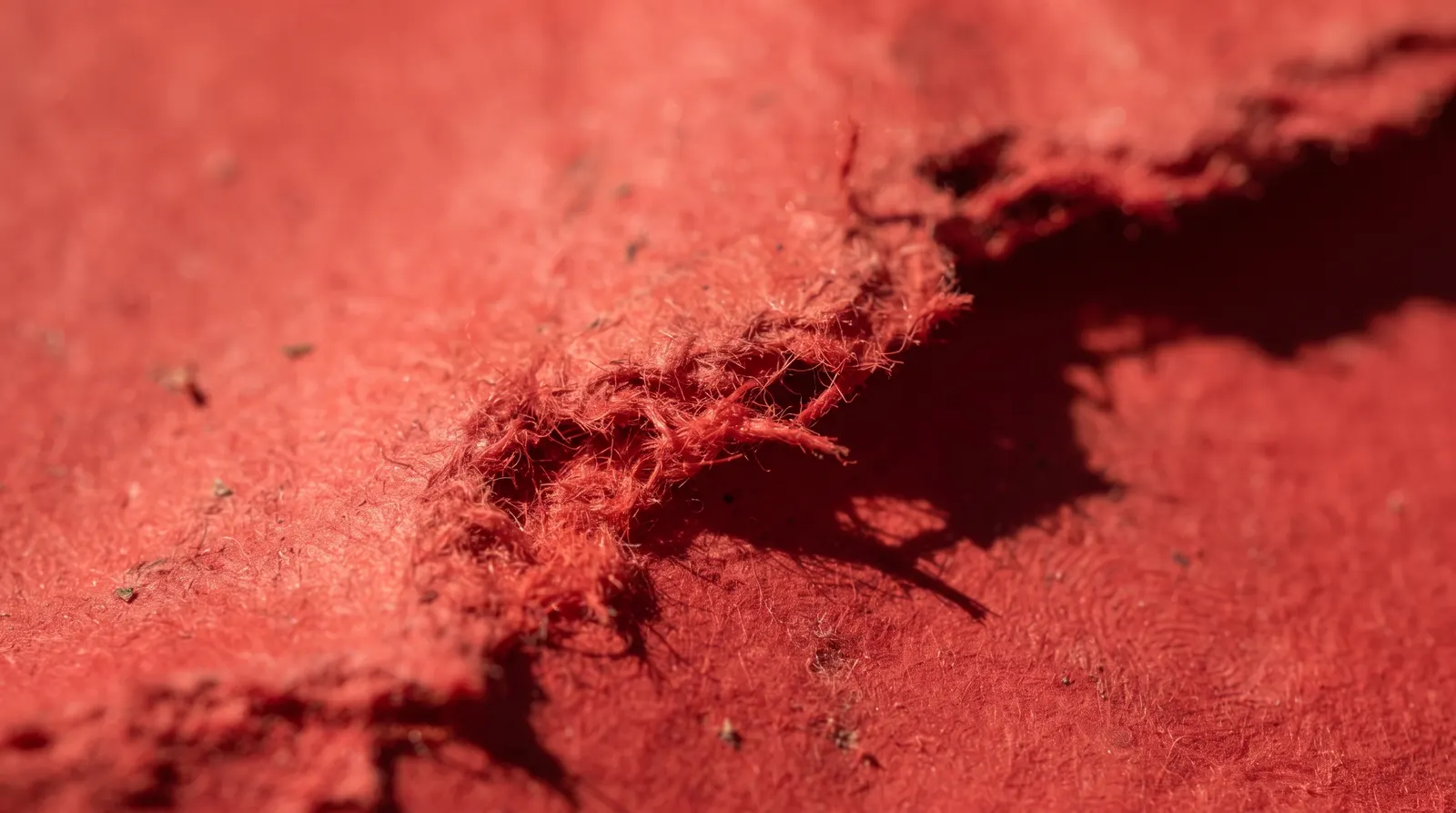 A torn edge of red fabric